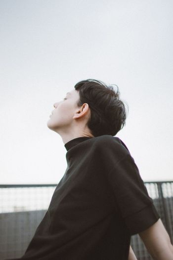 PORTRAIT OF MAN LOOKING AWAY AGAINST SKY