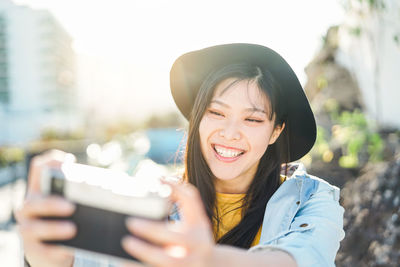 Smiling young woman taking selfie from camera