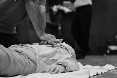 Midsection of man performing cpr on dummy 