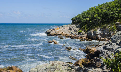 Rocks by sea against sky