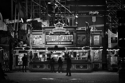 People in illuminated city at night