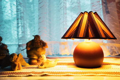 Close-up of illuminated toys on table against window