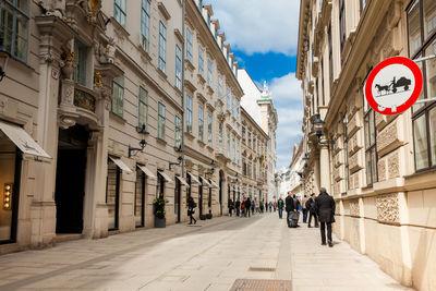 Horse-drawn vehicles likely to be in road sign at a beautiful street on vienna inner city