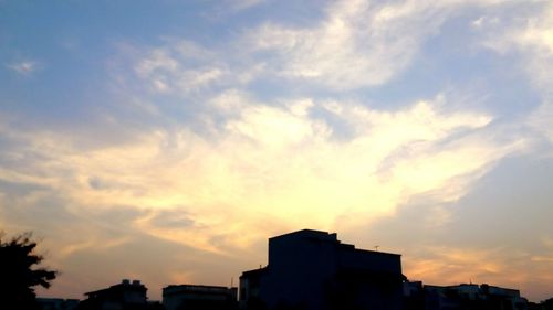 Silhouette of buildings against cloudy sky