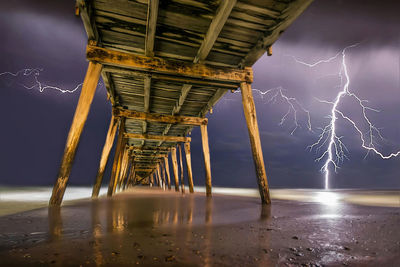 Bridge over sea against sky at night