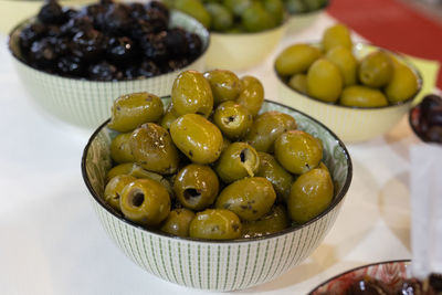 Fresh green and black, italian pitted olive in little bowl.