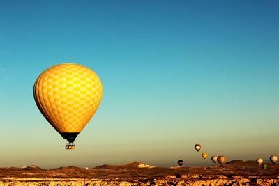 Hot air balloons flying against clear blue sky