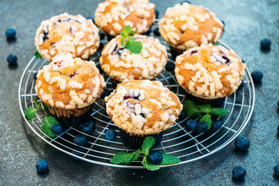 Close-up of cupcakes and fruits on cooling rack