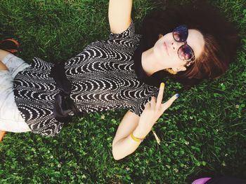 High angle portrait of young woman lying on grass