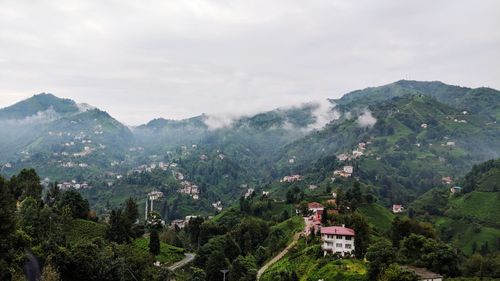 Aerial view of townscape by mountains against sky