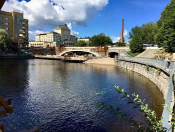 Bridge over river against buildings in city