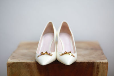 Close-up of shoes on table against wall