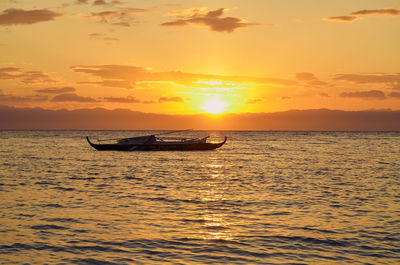 Silhouette boat in sea against sky during sunset