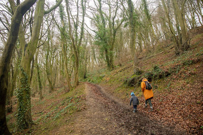 Woman walking in the forest pathway with her son. 