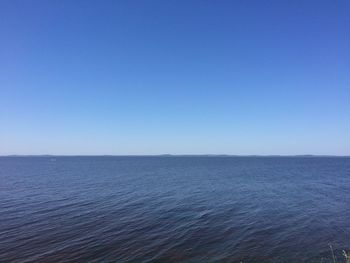 Scenic view of sea against clear blue sky