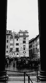 People on street by buildings against clear sky