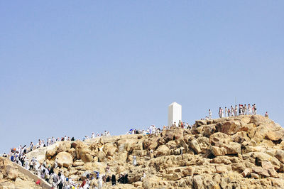 Panoramic view of people against clear blue sky