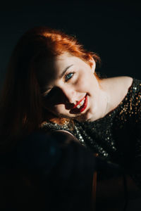 Portrait of redhead female singer woman in sparkly evening dress holding microphone. singer at