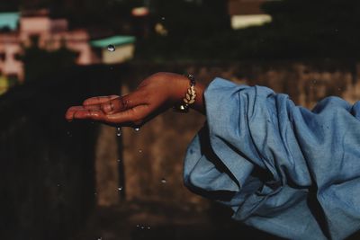 Cropped image of hand holding water at night