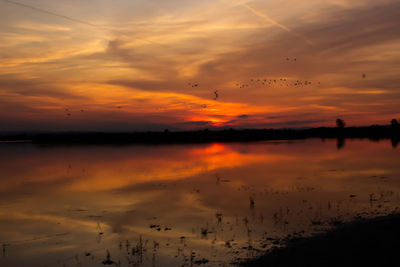 Scenic view of lake against romantic sky at sunset