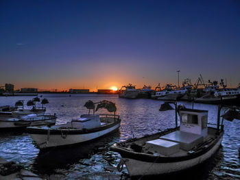 Boats in sea at sunset