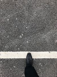 Low section of man standing on road