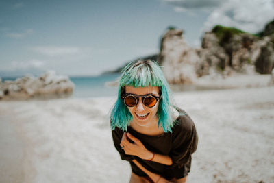 Portrait of young woman wearing sunglasses while standing on snow