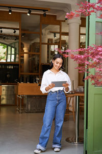 Portrait of young woman standing at home