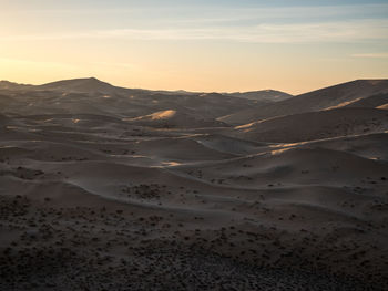 Scenic view of desert against sky during sunset