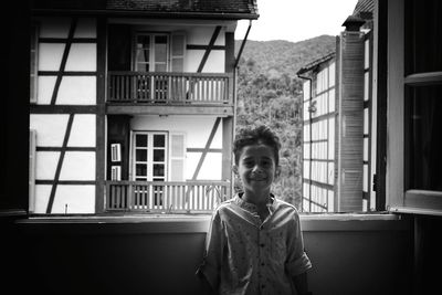 Portrait of boy standing against building