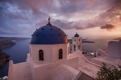 Church by building against sky during sunset