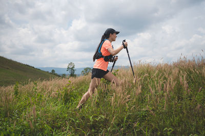 Full length of woman standing on field against sky