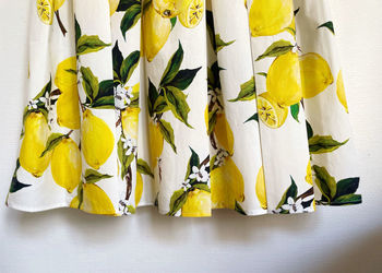 Close-up of crumpled pleated lower section of citrus print dress 