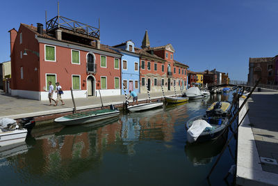 Boats moored in canal against clear sky