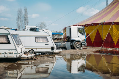 Side view of camper vans against cropped tent