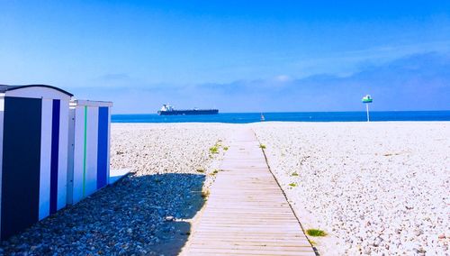 Scenic view of beach against blue sky