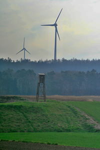 Windmill on field against sky