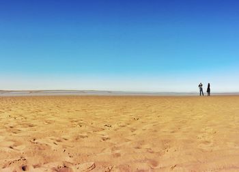 Scenic view of beach against blue sky