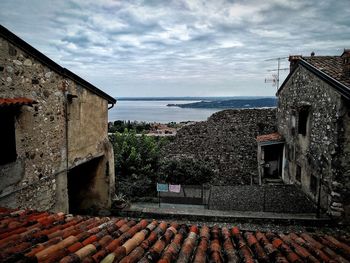 Houses by sea against sky in town