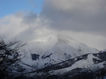 Low angle view of snow covered mountain against sky