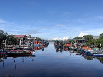 Boats moored in canal by buildings in city