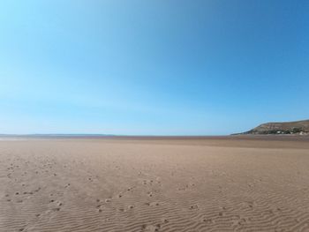 Scenic view of beach against clear blue sky