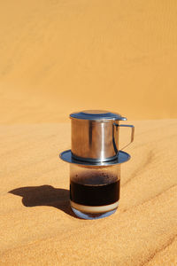 Drip black coffee in vietnamese style with condensed milk on a sand, top method of making coffee.