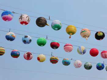 Low angle view of lanterns hanging against clear sky