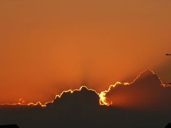 Scenic view of silhouette mountains against orange sky