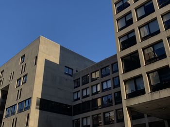 Low angle view of modern building against clear blue sky