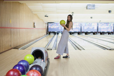 A young woman bowling.