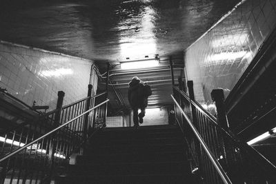 Low angle view of person walking on illuminated steps at railroad station