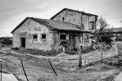 Abandoned house on field against sky