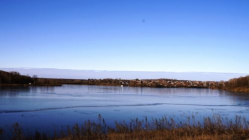 Scenic view of calm lake against clear blue sky